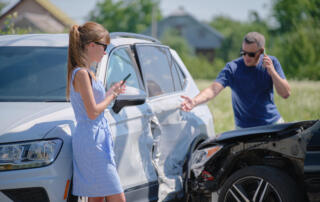 Angry Woman And Man Drivers Of Heavily Damaged Vehicles Calling Insurance Service For Help In Car Crash Accident On Street Side. Road Safety Concept