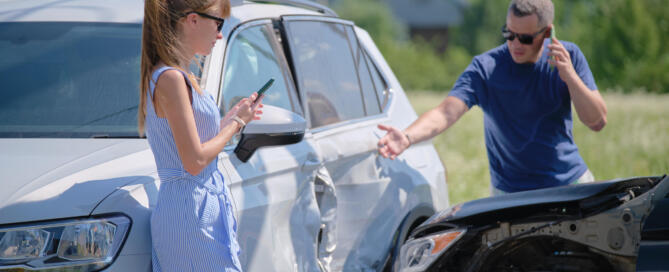 Angry Woman And Man Drivers Of Heavily Damaged Vehicles Calling Insurance Service For Help In Car Crash Accident On Street Side. Road Safety Concept