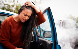 Female Motorist With Head Injury Getting Out Of Car After Crash