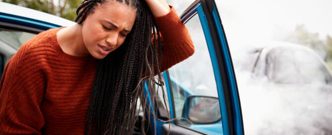 Female Motorist With Head Injury Getting Out Of Car After Crash