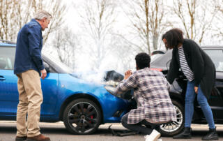 Young Couple Take Photos On Mobile Phone Of Damage To Car In Accident With Senior Driver