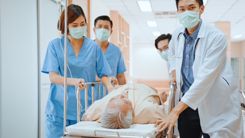 Emergency doctors and nurse team wear face mask, push emergency stretcher for a catastrophic injury victim