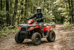 A person wearing safety gear sitting on a red ATV on a wooded trail near Minneapolis, representing off-road vehicle injury and safety.