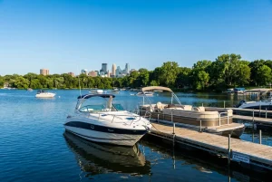 A motorboat and pontoon docked on a calm Minneapolis lake, representing local boating safety and personal injury legal services.